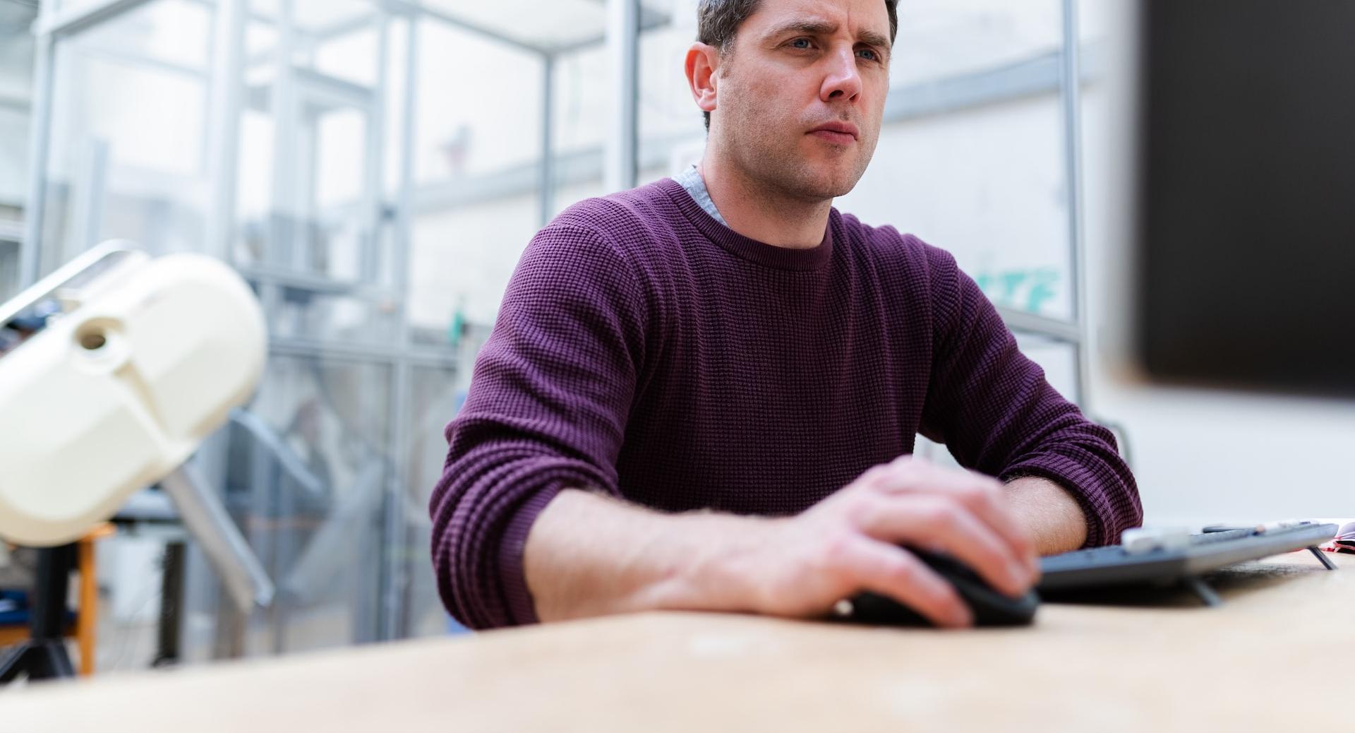 man in purple sweater sitting at the table